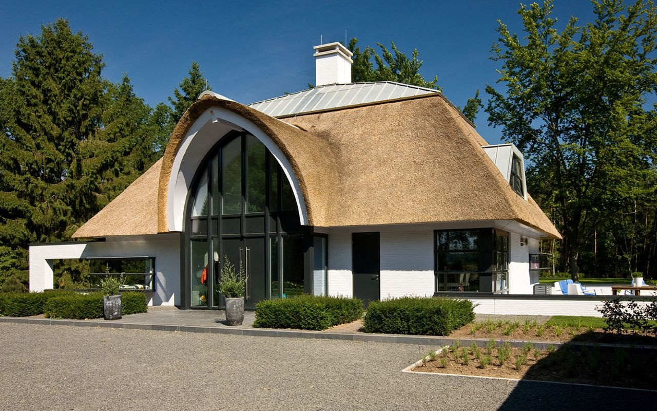 Witte nieuwbouwwoning in Hellendoorn met grote gevel en rieten dak, gebouwd door Bouwbedrijf Braamhaar.