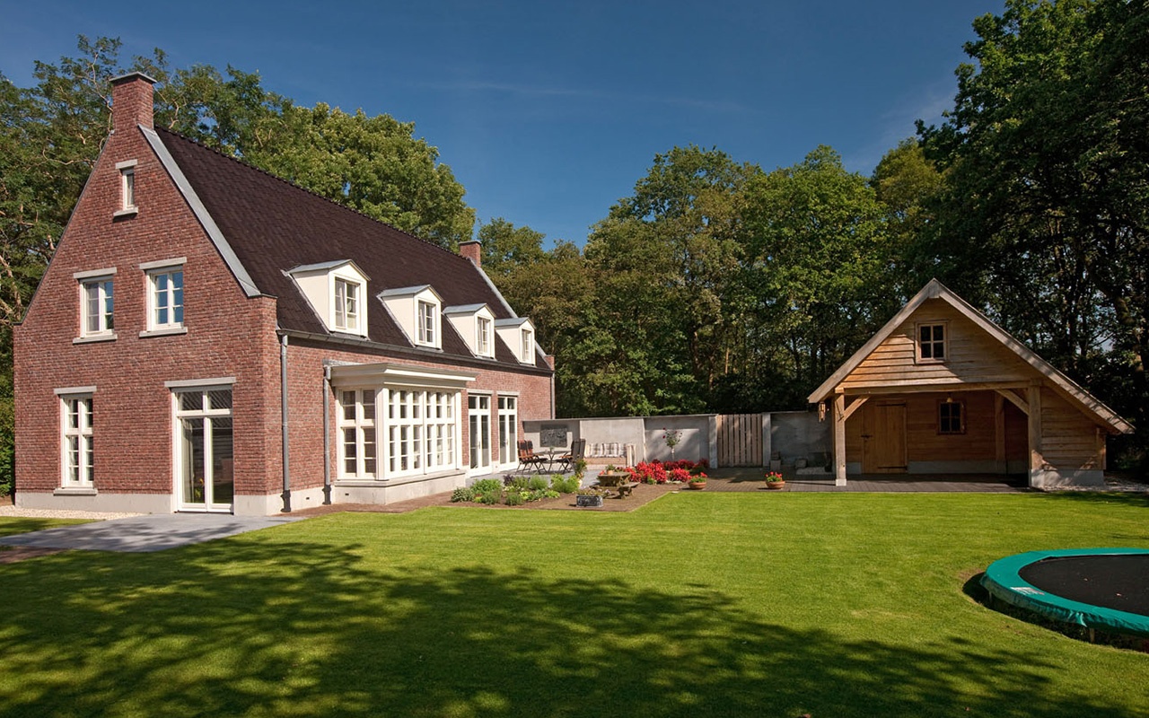 Nieuwbouw woning van Hellendoorn met een bruine gevel met een grote tuin.